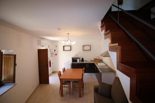 a small kitchen with a table and a staircase at Cascata do Varosa - Turismo Rural in Vila Pouca