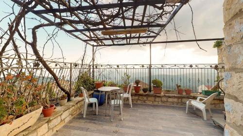 a patio with a table and chairs and potted plants at HEMDAT NEFESH in Safed