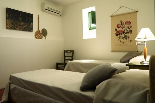 a room with two beds and a table with a lamp at Agriturismo Francesca Stajano in Alezio