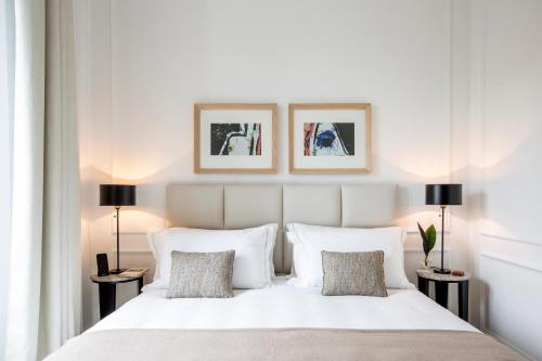 a bedroom with a large white bed with two lamps at Residenza B in Rome