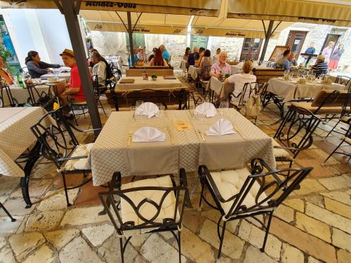 a restaurant with tables and chairs and people sitting at tables at Hotel Rendez Vous in Kotor