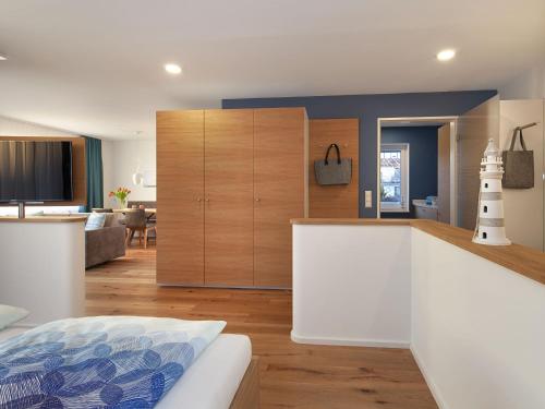 uma cozinha com um balcão branco e uma sala de estar em Appartements Bank am See em Immenstaad am Bodensee