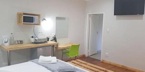 a bedroom with a desk and a bed and a desk at George Executive Suites in George