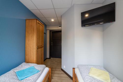 グダニスクにあるホステル フィリップのベッド2台、壁掛けテレビが備わる客室です。