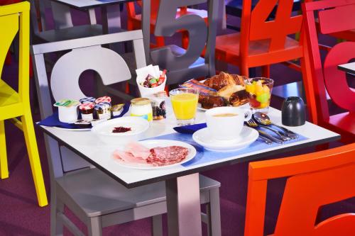 a table with breakfast foods and drinks on it at Hôtel Confort La Rochelle Centre les Minimes in La Rochelle