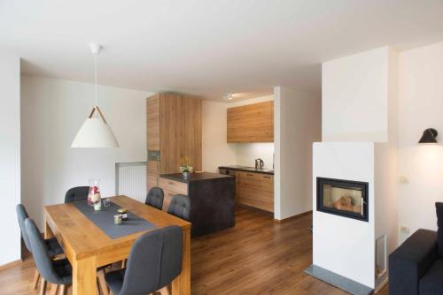 a dining room and living room with a table and a fireplace at Apartments Sivka - Private Sauna in Cerklje na Gorenjskem