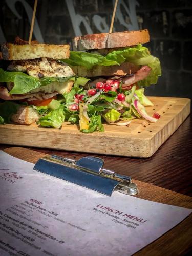 a sandwich on a wooden cutting board with a knife at Peak Edge Hotel in Chesterfield