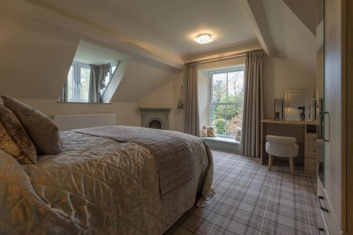 a bedroom with a bed and a fireplace and a window at Woodhaven - Luxury 4 bedroom rural retreat with hot tub near to Lake District in Grange Over Sands