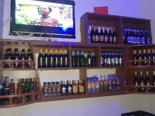 a bar with a tv and lots of bottles at FREEDOM Guest House in Wakiso