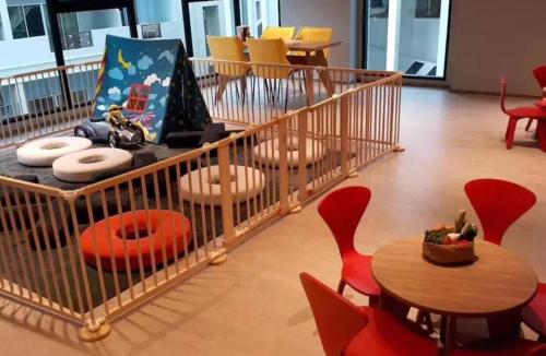 a room with a crib with chairs and a table at the base in Pattaya Central