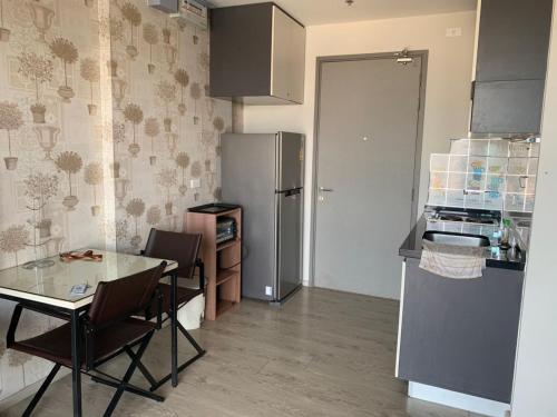 a small kitchen with a table and a refrigerator at the base in Pattaya Central