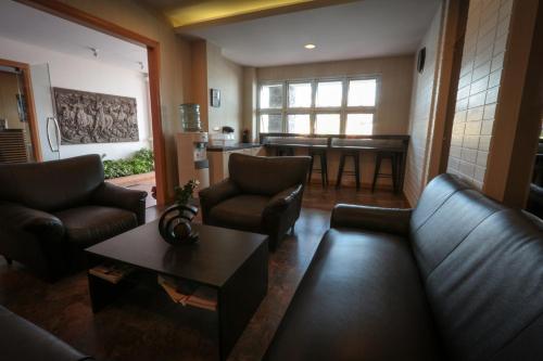 a living room with a couch and chairs and a table at Fortune Surin Hotel in Surin