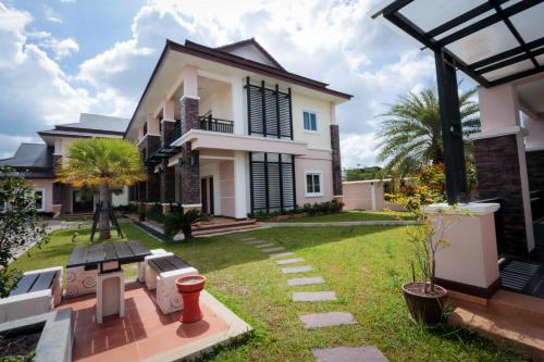 a house with a lawn in front of it at Fortune Surin Hotel in Surin