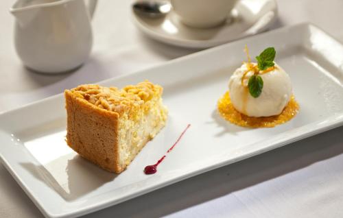 a white plate with a piece of cake and ice cream at Oude Werf Hotel in Stellenbosch