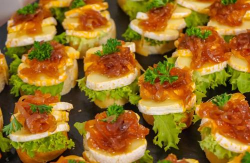 a tray filled with sandwiches with cheese and sauce at Gästehaus am Oberlausitzer Dreieck in Bertsdorf