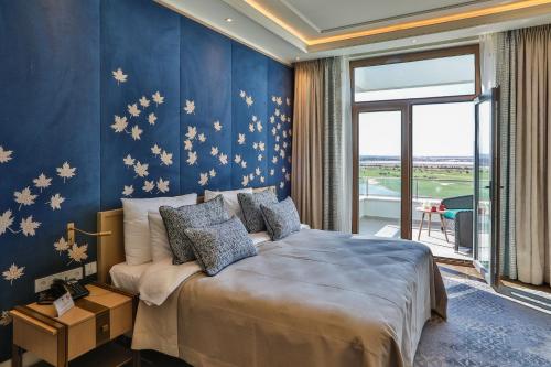 Dreamland Golf Hotel Baku في باكو: غرفة نوم بسرير كبير بجدران زرقاء