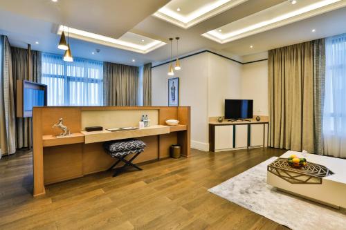 a living room with a desk and a tv at Dreamland Golf Hotel Baku in Baku