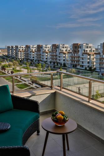 a balcony with a couch and a bowl of fruit on a table at Dreamland Golf Hotel Baku in Baku