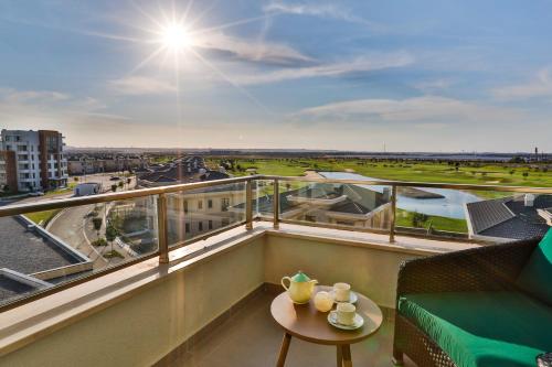 a balcony with a table and a view of a city at Dreamland Golf Hotel Baku in Baku
