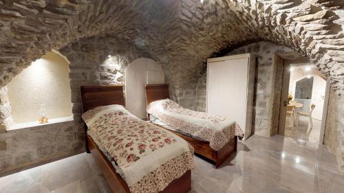 a bedroom with two beds in a stone room at HEMDAT NEFESH in Safed