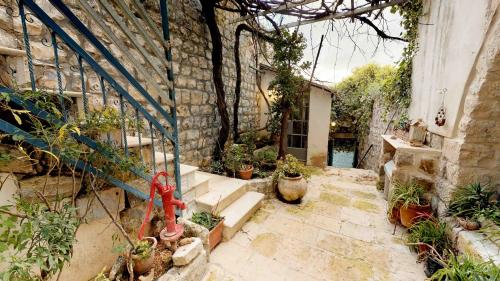 a courtyard with plants and a stone building at HEMDAT NEFESH in Safed