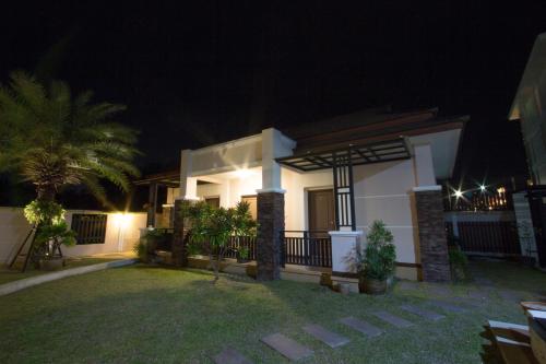 a house at night with lights in the yard at Fortune Surin Hotel in Surin