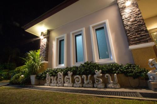 a house with a fence in front of it at night at Fortune Surin Hotel in Surin