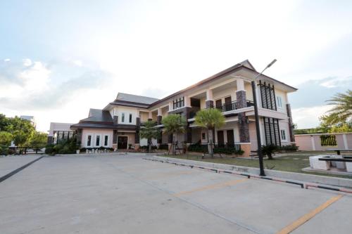 a large building with a parking lot in front of it at Fortune Surin Hotel in Surin