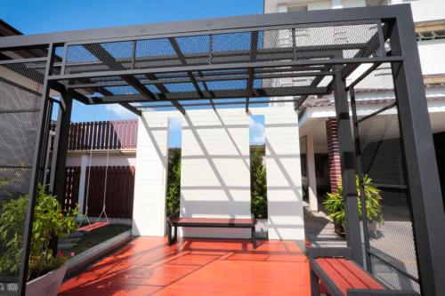 a pergola with a bench on a patio at Fortune Surin Hotel in Surin