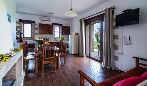 una cucina e un soggiorno con tavolo e sedie di Stay in Falassarna a Falasarna