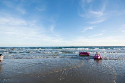 a pink boat on the beach next to the ocean at Grandbeach2 B52 By malai in Mae Pim