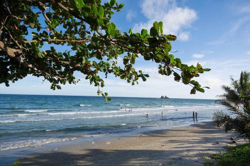 a beach with people standing in the water at Grandbeach2 B52 By malai in Mae Pim
