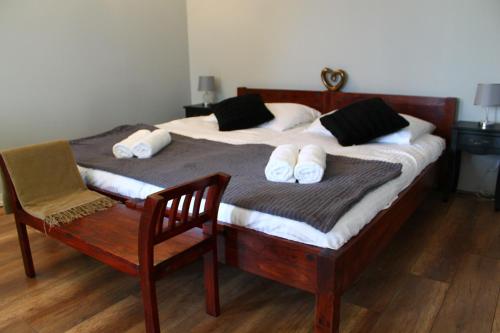 a bedroom with a bed with a chair and two beds at Varga Villa in Orfű