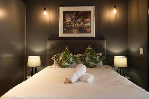 a bedroom with a bed with two lamps on it at Wex 1 Apartments in Cape Town