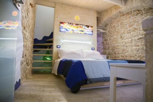 1 dormitorio con 1 cama en una pared de ladrillo en Vico Santa Maria en Putignano
