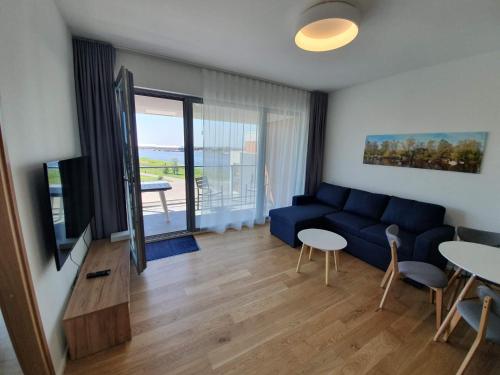 a living room with a blue couch and a table at Viiking Spa Hotel in Pärnu