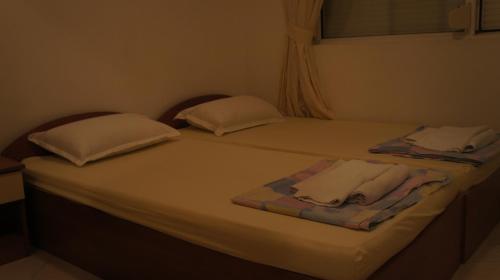 ein Bett mit zwei Handtüchern und zwei Kissen darauf in der Unterkunft Bravo 5 Apartments in Sonnenstrand