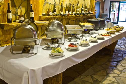 a long table with plates of food and bottles of wine at Hotel Polar Star in Žabljak