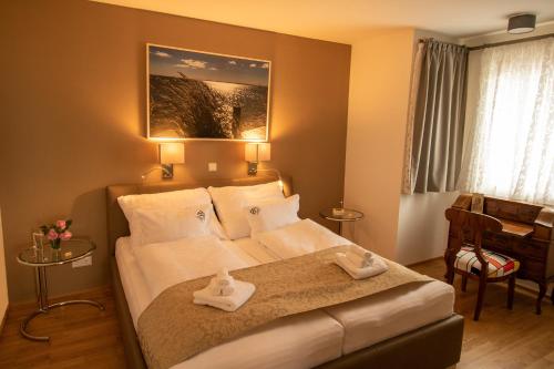 a bedroom with a bed with two towels on it at Pannonia Appartements in Neusiedl am See