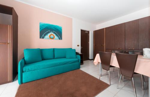 a living room with a blue couch and a table at Loano 2 Village in Loano