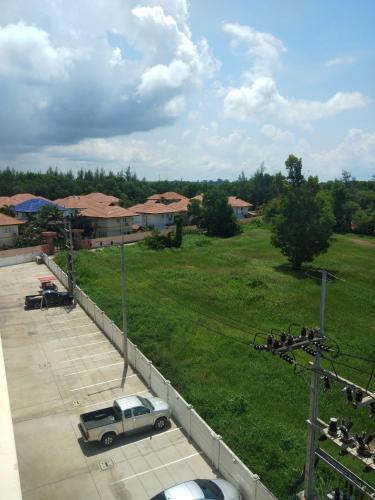 a truck parked in a parking lot next to a field at Grandbeach2 B52 By malai in Mae Pim
