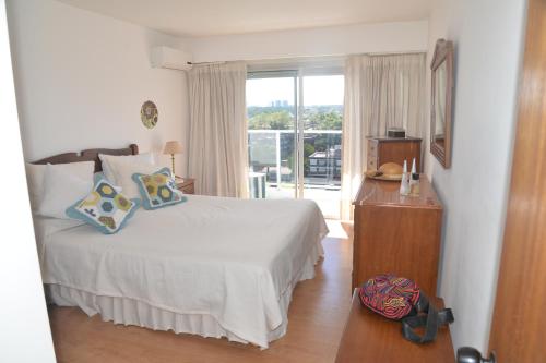 a bedroom with a bed and a window at Long Beach, Parada 3 in Punta del Este