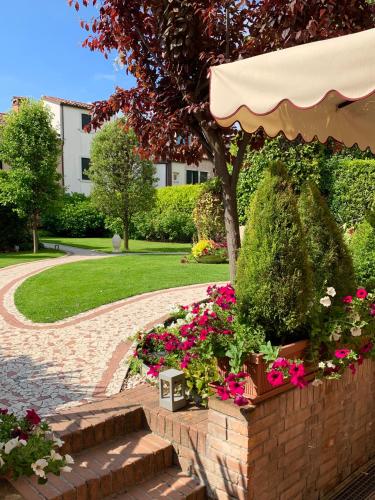 a garden with flowers and a brick walkway at Hotel Olimpia Venice, BW Signature Collection 3sup in Venice