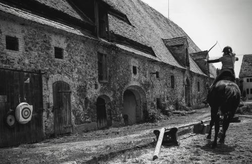 a woman riding a horse in front of a building at Studniska Country Estate in Studniska