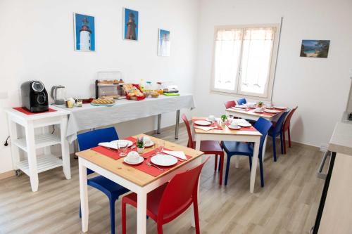 un comedor con mesas y sillas con comida. en B&B Il Viaggiatore en Tortolì