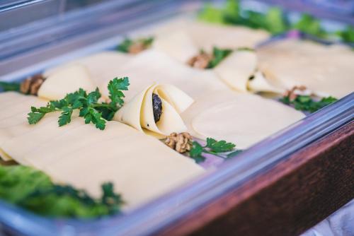 a tray of food with cheese and parsley on it at Hotel Forum in Rzeszów