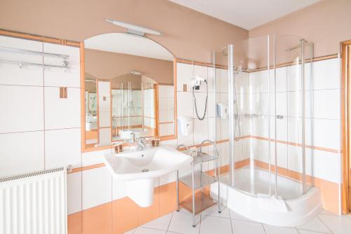 a bathroom with a sink and a shower at Hotel Forum in Rzeszów