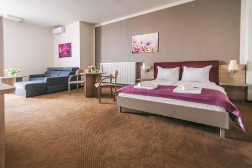 a bedroom with a bed and a living room at Hotel Forum in Rzeszów