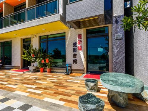 a building with a table and rocks in front of it at Lisinty Resort in Hengchun