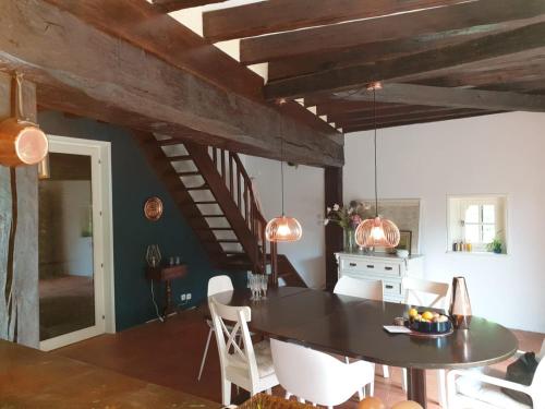 a kitchen and dining room with a table and chairs at Moulin en Route in Blèves
